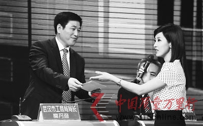 主持人問高局長:信封現(xiàn)如今還有什么作用?隨后,將一個空信封送到高局長手中…… 記者陳亮 攝