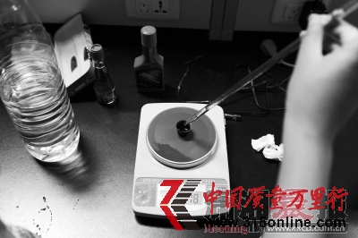 　　給實驗用的93號汽油樣本稱重。
